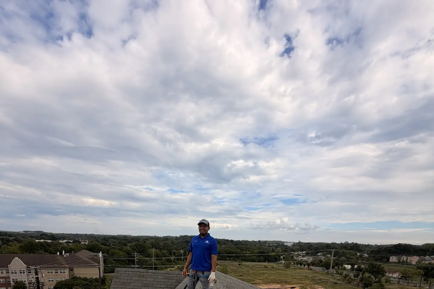 An RC All Exteriors professional on the roof during a flat roof installation