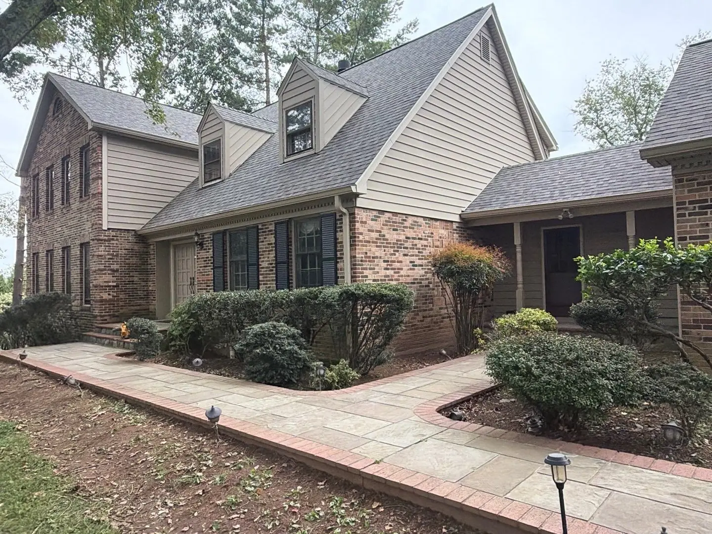 New gray-brown shingle roof on a two-story home, a roof replacement by RC All Exteriors