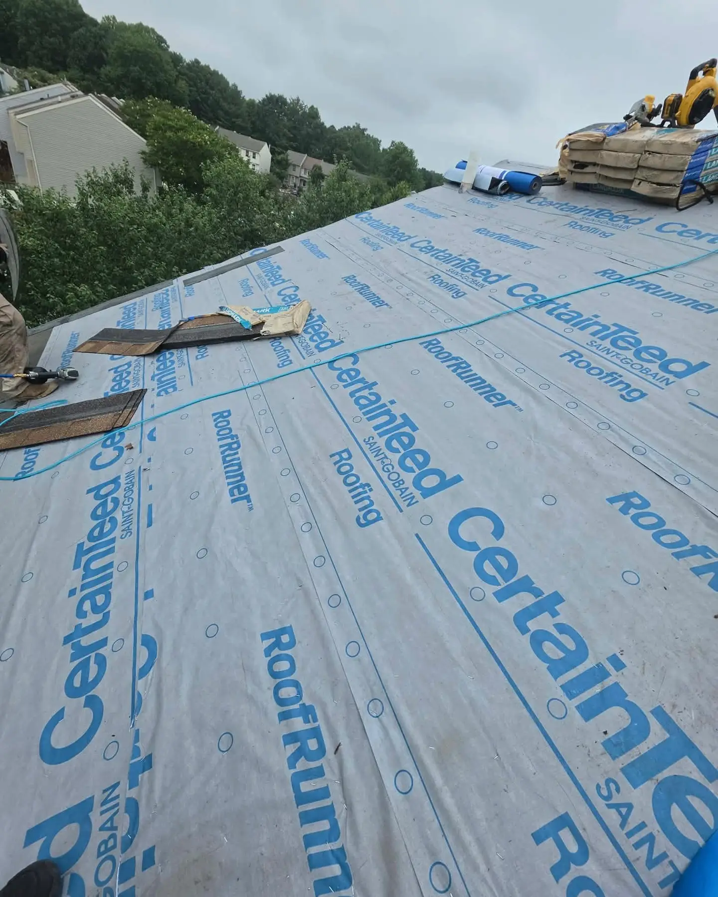 Roof replacement in progress: old shingles removed and new underlayment going down