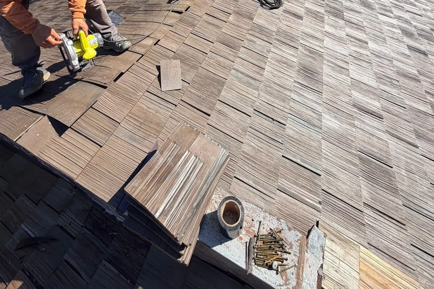 Roofer installing Brava synthetic shake on a mansard roof